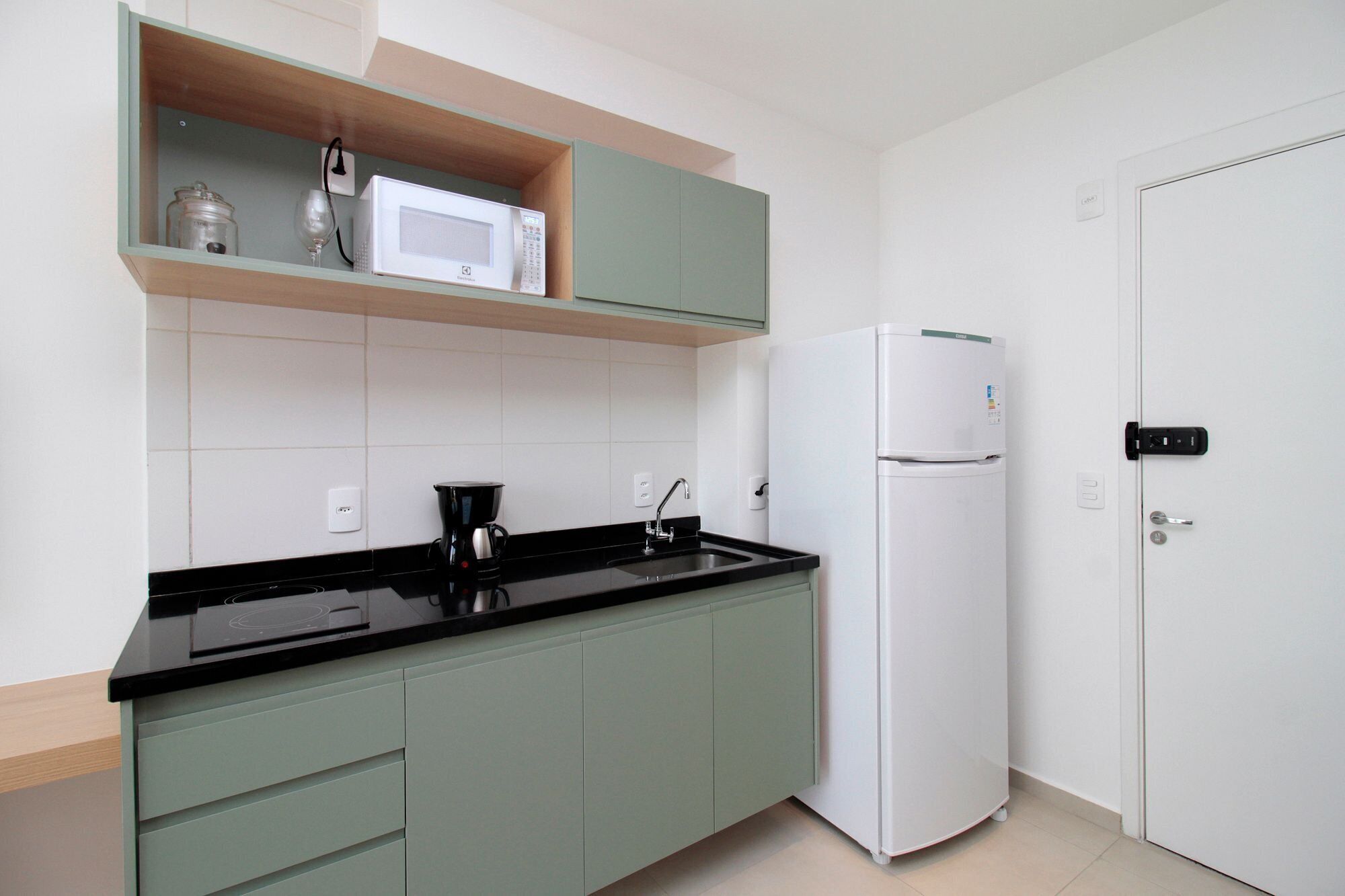 Comfort appartement | Privékeuken | Een koelkast met diepvriezer, kookgerei, borden en bestek