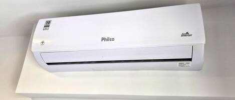 A white Philco air conditioner with an Eco Inverter label, placed on a white surface.