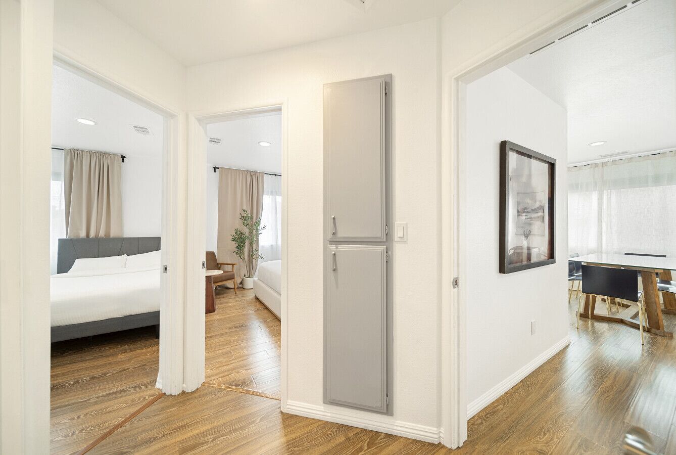 A hotel room with a bed, a desk, and a door.