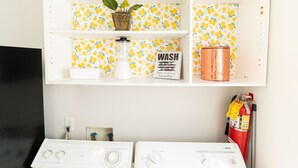 A laundry area with two washing machines, a plant, a water dispenser, and a fire extinguisher. - Sun cottage near downtown (Columbus)