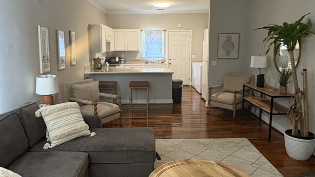 A living room with a gray sectional sofa, a wooden coffee table, and a ceiling fan.