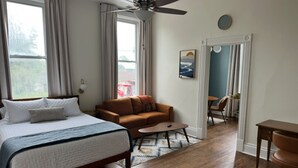 A bedroom with a bed, a sofa, a coffee table, and a desk. - Boutique Studio Apartment (La Porte)