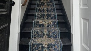 A staircase with a patterned carpet leading to a room. - Boutique Studio Apartment (La Porte)
