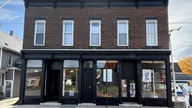 A two-story brick building with a black facade, large windows, and a prominent entrance. - Boutique Studio Apartment (La Porte)