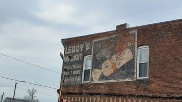 En murstensbygning med et falmet mural, der reklamerer for Leroy's Market.