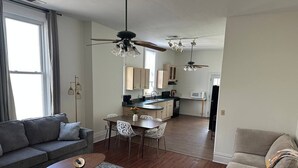 A modern living room with a sofa, coffee table, and dining area.