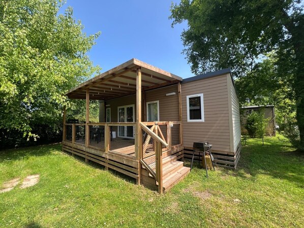 Eine kleine Holzhütte mit Veranda und einem umzäunten Deck.