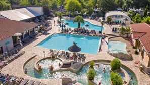 Ein Resort mit mehreren Schwimmbecken, darunter ein zentrales Becken und kleinere Pools mit Wasserspielen.