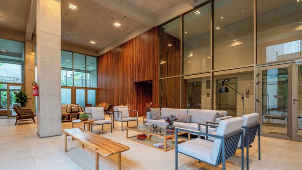A spacious lobby with a large seating area, a wooden accent wall, and large windows providing natural light. - 360 SP Faria Lima (São Paulo)