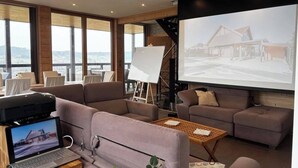 Ein modernes Wohnzimmer mit Sofas, einem Couchtisch und einem Laptop auf einem Holztisch.