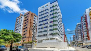 A multi-story building with a modern architectural design, featuring a mix of brick and glass facades. - Cozy Apartment Near Maceio Beach Eaa805 (Maceió)