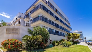 A multi-story hotel with a modern design, featuring balconies and a tiled facade.