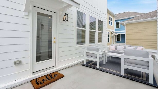 A white house with a front door, a bench, and a sofa outside. - 4BR home with  workspace & parking (Oxford)