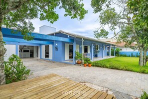 A blue house with a paved patio, potted plants, and a wooden deck. - 4BR Home w/ BBQ 100m From Beach Jat0355 (Bombinhas)