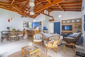 A spacious living area with wicker furniture, a dining table, and a kitchen in the background. - 4BR Home w/ BBQ 100m From Beach Jat0355 (Bombinhas)