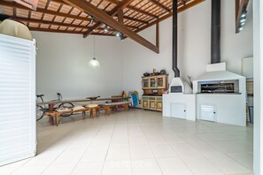 A spacious kitchen with a large stove, wooden benches, and a bicycle in the background. - 4BR Home w/ BBQ 100m From Beach Jat0355 (Bombinhas)