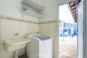 A small laundry room with a washing machine and a sink. - 4BR Home w/ BBQ 100m From Beach Jat0355 (Bombinhas)
