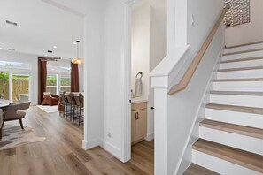 Un intérieur moderne avec un escalier, un coin repas offrant une vue agréable et une cuisine dotée de meubles en bois.