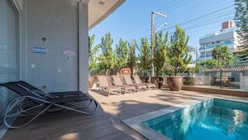 Ett område vid poolen med solstolar och en liten pool.