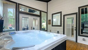A modern bathroom with a large bathtub, wooden flooring, and large windows. - Kid Friendly! Foosball, Playset, 3 Arcades (Broken Bow)