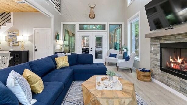 A spacious living room with a large sectional sofa, a fireplace, and a mounted deer head. - Kid Friendly! Foosball, Playset, 3 Arcades (Broken Bow)