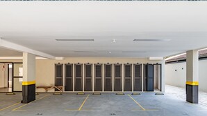 Un parking avec des places numérotées et une rangée de casiers fermés.