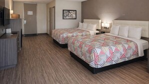 A hotel room with two beds, a desk, a TV, and a door. - Motel 6 – Lake City, Fl – Medical Center (Lake City)