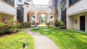 A courtyard with a central pathway, surrounded by buildings with balconies and arched walkways. - Beautiful Apartment in Asa Norte Brasilia Hin0117 (Brasília)