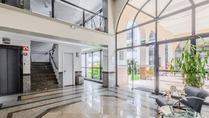 A spacious lobby with a glass coffee table, a staircase, and a view of the outside. - Beautiful Apartment in Asa Norte Brasilia Hin0117 (Brasília)