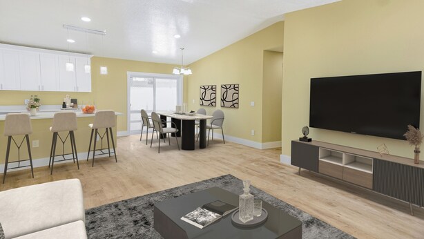 A modern living room with a flat-screen TV, a dining area with a table and chairs, and a kitchen with white cabinets and a bar counter. - Zoo House Down Town Tampa (Tampa)