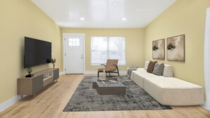 A living room with a flat-screen TV, a sofa, a coffee table, and artwork on the walls. - Zoo House Down Town Tampa (Tampa)
