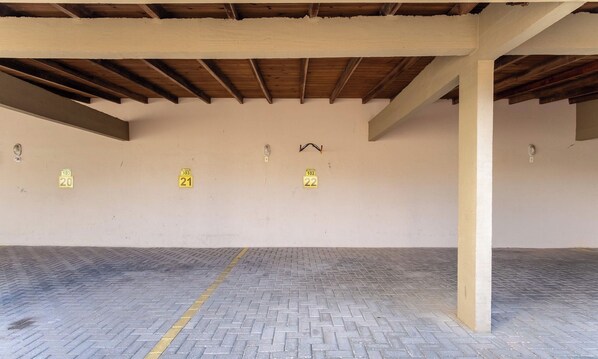 An empty parking garage with concrete floors and a wooden ceiling.