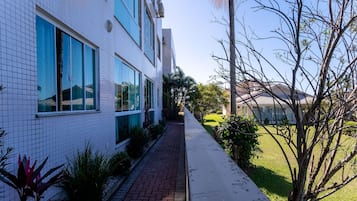 Un edificio moderno con ventanas amplias y un camino de ladrillo que conduce a un césped verde.
