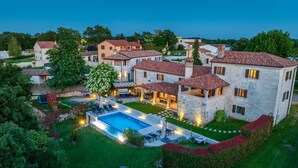 A large house with a swimming pool, outdoor seating, and a well-maintained garden.
