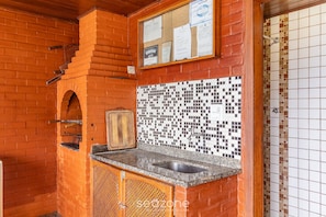 Uma cozinha com painel de azulejos, parede de tijolos e armário de madeira.