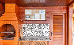 A brick oven with a tiled backsplash and a wooden door. - Duplex Overlooking Channel Cabo Frio-rj Fnx0101 (Cabo Frio)
