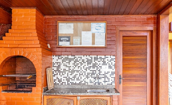 A brick oven with a tiled backsplash and a wooden door.