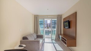 A modern living room with a sofa, a coffee table, and a TV mounted on the wall. - Apt Between Braga Beach and Forte Beach - Fmi0218 (Cabo Frio)
