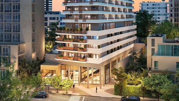 Un moderno edificio de gran altura con varios balcones y una entrada a nivel de calle.
