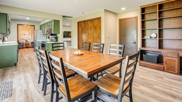 A dining area with a wooden table and chairs, a kitchen in the background, and a wooden cabinet with shelves. - 12 Mi to Mississinewa Lake: Peaceful Retreat (Amboy)
