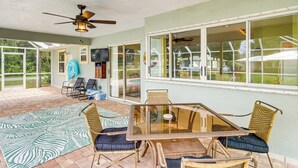 A covered patio area with a glass table and wicker chairs, a ceiling fan, and a view of the outdoors. - 7 Mi to River & Ocean: Family Getaway in Sebastian (Sebastian)
