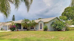 A two-story house with a front porch, a lawn, and a variety of plants and trees. - 7 Mi to River & Ocean: Family Getaway in Sebastian (Sebastian)