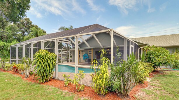 A covered outdoor area with a pool, surrounded by various plants and a house in the background. - 7 Mi to River & Ocean: Family Getaway in Sebastian (Sebastian)