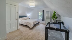 A bedroom with a bed, a window, a desk, and a plant. - Cozy 4BR Home by Tufts w/ Subway Access to Downtown, MIT, Harvard + Free Parking (Medford)