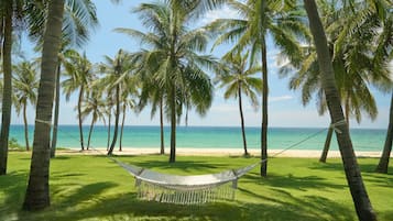 En la playa, arena blanca, sillas reclinables de playa, sombrillas