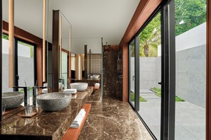 A modern bathroom with large granite sinks, a glass shower enclosure, and a view of greenery outside. - JW Marriott Cam Ranh Bay Resort & Spa (Cam Lam)