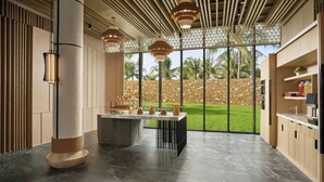 A modern kitchen with a large island, pendant lighting, and a view of a garden through large windows. - JW Marriott Cam Ranh Bay Resort & Spa (Cam Lam)