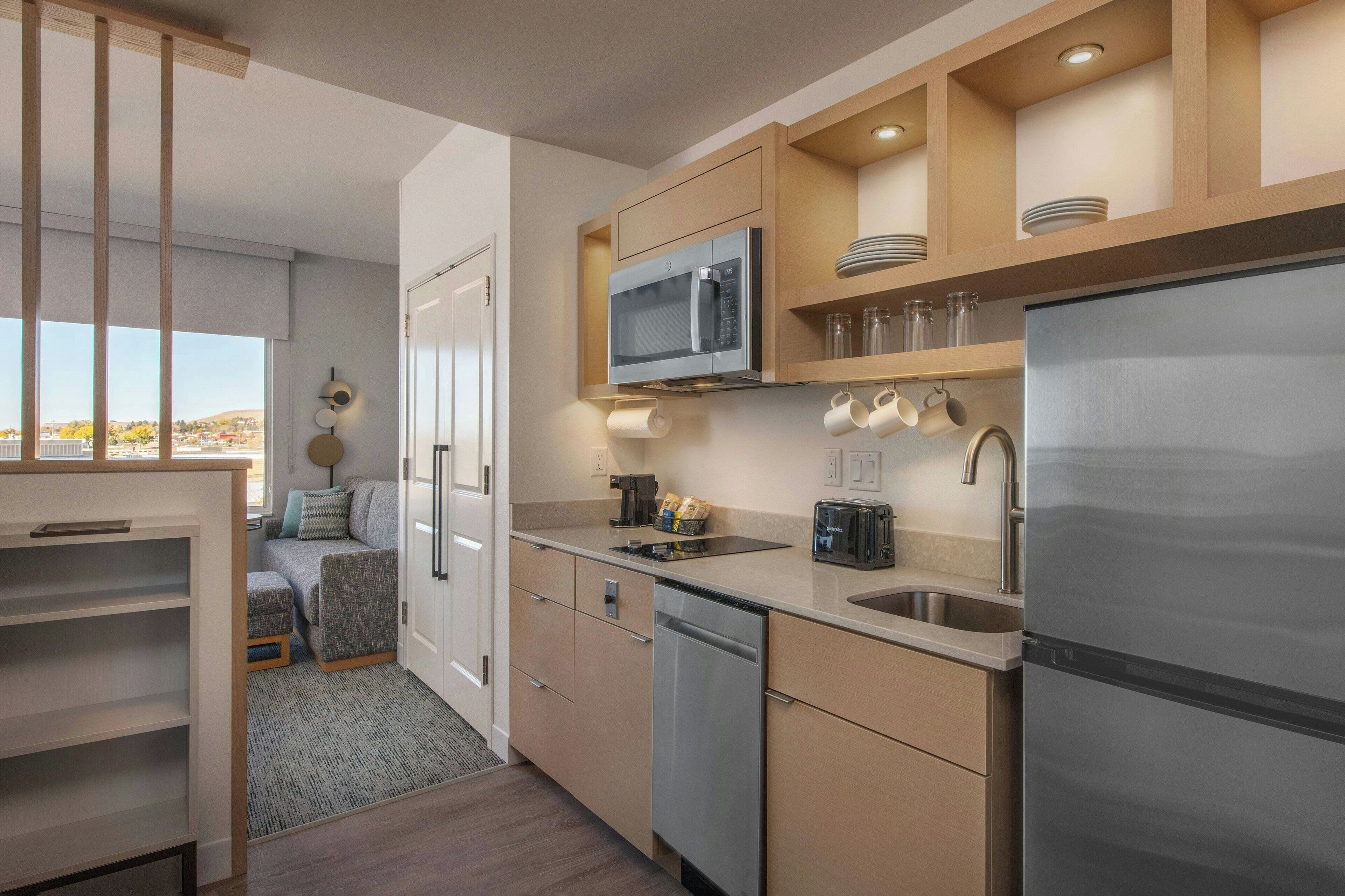 A modern kitchen with a built-in microwave, stainless steel appliances, and a view to the outside.