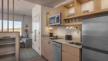 A modern kitchen with a built-in microwave, stainless steel appliances, and a view to the outside.