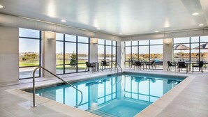 An indoor swimming pool with clear views of the outdoors, large windows, and a seating area with tables and chairs. - Towneplace Suites By Marriott Great Falls (Great Falls)